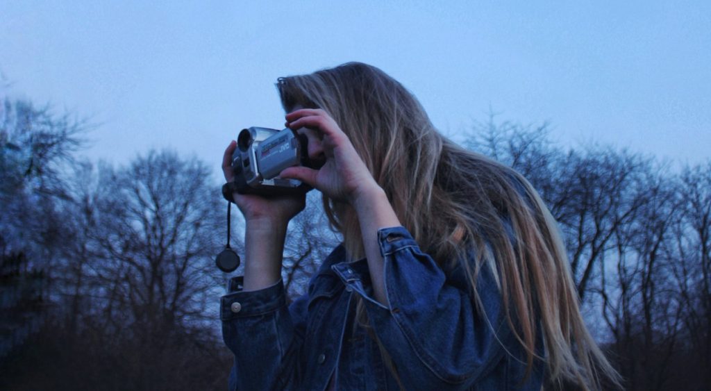 a woman taking a picture of the moon with a camera